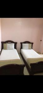 twee bedden naast elkaar in een kamer bij Appartement lumineux et spacieux en plein centre ville in Ouarzazate