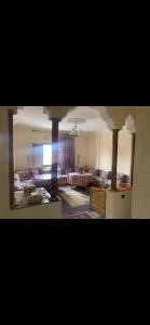 een kamer met een bed en een woonkamer bij Appartement lumineux et spacieux en plein centre ville in Ouarzazate