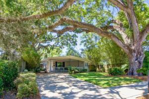 a house with a large tree in front of a driveway at Orlando Vacation Rental Less Than 2 Mi to Lake Ivanhoe! in Orlando