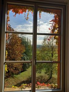 une fenêtre ouverte avec vue sur un arbre dans l'établissement Maison d'Adèle au hameau de Banne, 