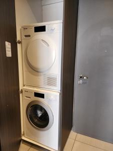 a washer and dryer in a room with a door at The Trilogy Penthouse 1603 in Pretoria