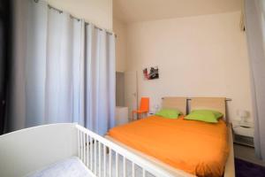 una camera da letto con letto arancione e cuscini verdi di Maison conviviale à Sainte-Anne avec piscine privée a Sainte-Anne Altre 28 foto