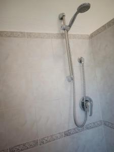 een douche met een douchekop in de badkamer bij B&B Gorropis in Siniscola