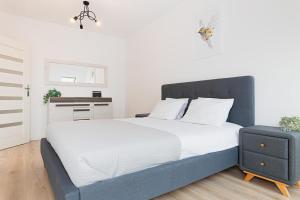 une chambre avec un grand lit avec des draps blancs dans l'établissement DreamHouse Apartament BURSZTYNOWY ul Wschodnia 12, Darłówko Wschodnie, à Darłówko