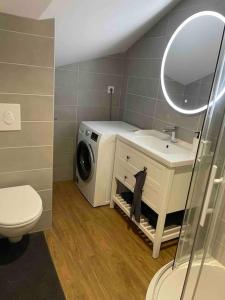 een badkamer met een wasmachine en een wastafel bij K-torze in Espalion