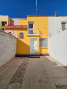 un edificio blanco y amarillo con suelo de madera en Sensity Home Casa Novedosa Céntrica y Linda, en Tehuacán