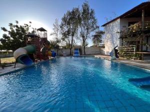 a swimming pool with a slide in the middle at Pousada das Canoas in Acaraú