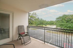 una silla sentada en el balcón de una casa en Ocean Club Villa C-207, en Biloxi