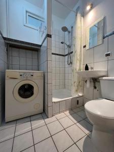 een badkamer met een wasmachine en een wastafel bij Gdynia Śródmieście Necla Apartament in Gdynia