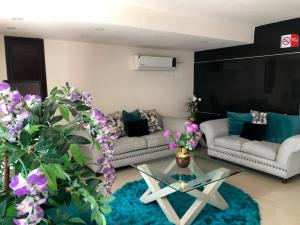 sala de estar con sofá, mesa y flores en Hotel Francis en Culiacán
