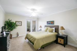 Un dormitorio con una cama y un ventilador de techo. en Ocean Club Villa C-207, en Biloxi