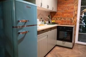 a blue refrigerator in a kitchen next to a sink at Zielony Domek/Green House in Załakowo +2 photos