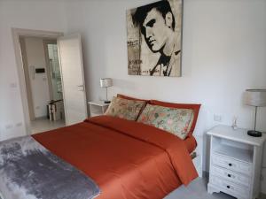 una camera da letto con un letto arancione e un dipinto sul muro di Maison de Famille a Torino