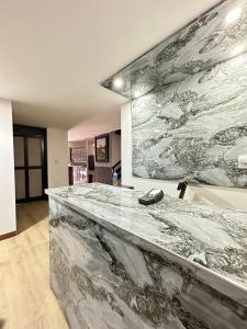 a marble counter in a room with a large painting on the wall at Hotel Lares 70 Laureles in Medellín
