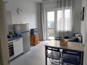 cocina y sala de estar con mesa y nevera en Maison de Famille, en Turín