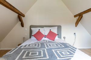 una camera con un letto con due cuscini rossi di Gîte de l'étoile 3 chambres - jacuzzi a Achenheim