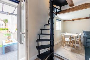 a black spiral staircase in a small room with a table at Gîte de l'étoile 3 chambres - jacuzzi in Achenheim