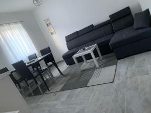 sala de estar con sofá negro y mesa en Villa Nana, en Kulen Vakuf