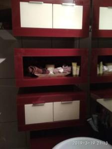 a bathroom with red and white cabinets and a sink at Anchors Aweigh-Sea View Apart. in Nea Skioni