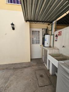 a garage with a white door and a refrigerator at Sensity Home Casa Novedosa Céntrica y Linda in Tehuacán