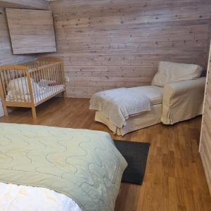 Habitación con 2 camas y pared de madera. en Anitas Villa i Kristdala, en Kristdala