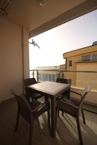 einen Tisch und Stühle auf einem Balkon mit Fenster in der Unterkunft Dyrrah Seaside Apartments in Durrës