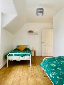 a bedroom with a bed with a green comforter at The Crows Nest in Eyemouth