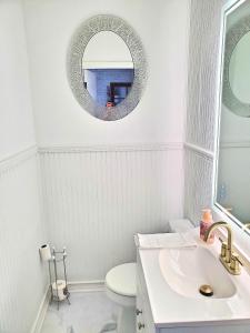 a white bathroom with a sink and a mirror at Porter Avenue House in Biloxi +18 photos
