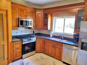 a kitchen with wooden cabinets and a stove top oven at Porter Avenue House in Biloxi