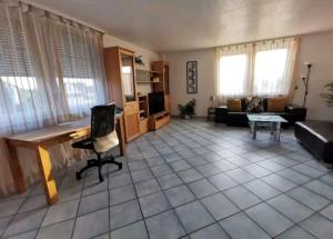 uma sala de estar com uma secretária e um sofá em Spacious 100sq m apartment em Tuchenbach