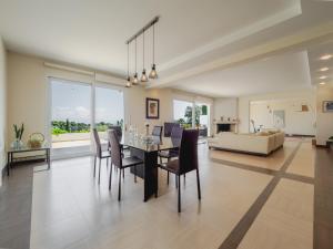 a dining room with a table and chairs and a couch at Villa Corfu Horizon in Kato Korakiana