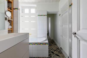 a white bathroom with a tub and a toilet at Appartement 2 chambres avec garage à strasbourg in Strasbourg +20 photos
