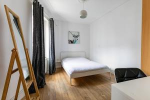 a small bedroom with a bed and a chair at Appartement 2 chambres avec garage à strasbourg in Strasbourg