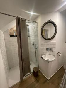 a bathroom with a shower and a sink and a mirror at Valletta's Charming Loft Accommodation in Valletta