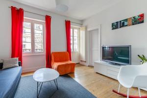 a living room with a couch and a tv at Appartement 2 chambres avec garage à strasbourg in Strasbourg