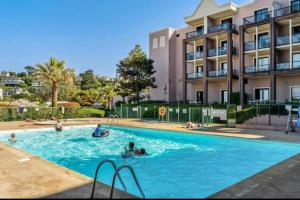 a swimming pool in front of a building at DANS LES BRAS DE NEPTUNE - Plage de TRESTRAOU - Piscine - 4 à 5 personnes in Perros-Guirec