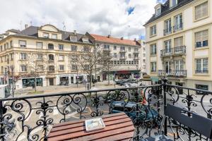 a wooden bench on a balcony with buildings at Appartement 2 chambres avec garage à strasbourg in Strasbourg