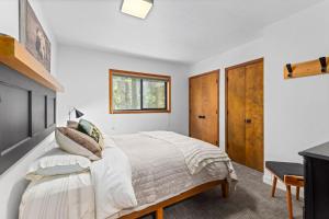 a bedroom with a bed with white sheets and a window at Sunnyside Retreat - Tahoe City, 4 BR, Pet Friendly, Bonus Room in Tahoe City