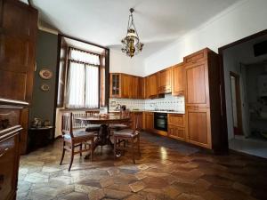 a kitchen with a table and chairs and a chandelier at 3RDomus - Luxury suite con vista Duomo in Turin