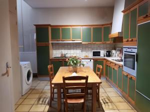 een keuken met groene kasten en een tafel met stoelen bij La maison de Louise in Fontenay-le-Comte