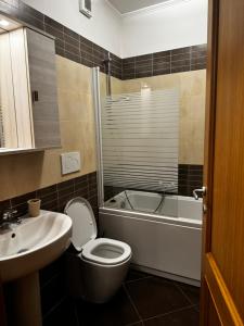 a bathroom with a toilet and a sink and a tub at DolceVita Eur Torrino Prestige in Rome