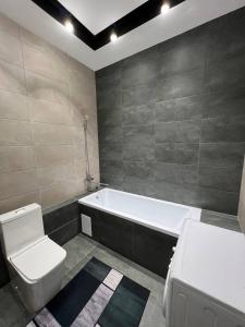 uma casa de banho com um WC e uma banheira em ЖК Terracotta em Almaty