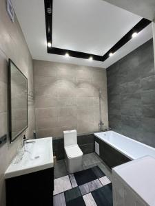 y baño con lavabo, aseo y bañera. en ЖК Terracotta, en Almaty