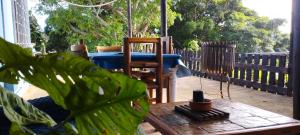 a wooden table and chairs on a patio with a table and a plant at Thalassa's in Port Shepstone