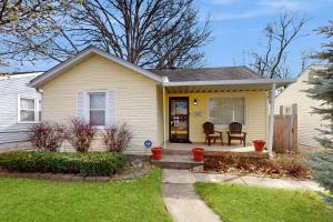 een geel huis met een tafel en stoelen in een tuin bij Little Yellow B&B in Indianapolis