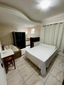 Schlafzimmer mit einem Bett, einem Waschbecken und einer Badewanne in der Unterkunft POUSADA BRASÃO in Governador Valadares
