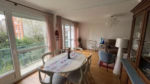 uma sala de jantar com uma mesa e cadeiras e uma janela em Appartement Boulogne-Billancourt nord Roland Garros em Boulogne-Billancourt