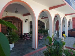 a courtyard of a house with arches and plants at APART STUDIOS PONTAL in Ilhéus