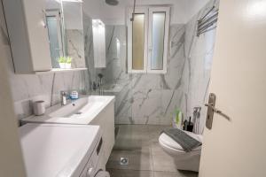 a white bathroom with a sink and a toilet at Psiri gem from In Vivo Apartments- Spacious 1st floor Apartment with Balcony in Athens' historic center in Athens