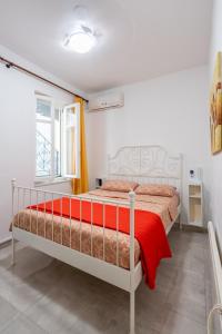 a white bedroom with a bed with a red blanket at Psiri gem from In Vivo Apartments- Spacious 1st floor Apartment with Balcony in Athens' historic center in Athens